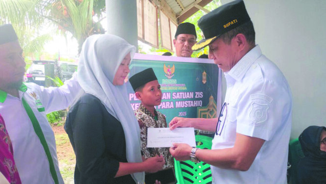 
 Bupati Butur Afirudin Mathara menyerahkan bantuan dana ZIS kepada para penerima manfaat, Rabu (7/5). FOTO: Ist