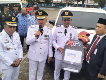 Pemimpin Bank Sultra Cabang Kolaka Syaparuddin Rusman (kanan) menyerahkan CSR berupa satu unit mobil Rangga, satu unit motor roda tiga, mesin alkon, dan mesin pemotong rumput kepada Bupati Kolaka H. Amri. FOTO: Kaulia Ode/ Kolaka Pos
