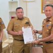 Sekda Amir Hasan saat menyerahkan SK plt Kepala Dinas Perpustakaan dan Arsip Kota Kendari kepada Akrim Kurdin. Foto Kadamu/Kolaka Pos