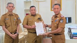 Sekda Amir Hasan saat menyerahkan SK plt Kepala Dinas Perpustakaan dan Arsip Kota Kendari kepada Akrim Kurdin. Foto Kadamu/Kolaka Pos