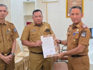 Sekda Amir Hasan saat menyerahkan SK plt Kepala Dinas Perpustakaan dan Arsip Kota Kendari kepada Akrim Kurdin. Foto Kadamu/Kolaka Pos