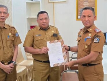 Sekda Amir Hasan saat menyerahkan SK plt Kepala Dinas Perpustakaan dan Arsip Kota Kendari kepada Akrim Kurdin. Foto Kadamu/Kolaka Pos