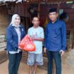 Ketua Partai Nasdem Kolaka, Hj. Sucianti Aras (kiri) bersama Sekretaris Nasdem Kolaka, Wardi (kanan) membagikan paket Ramadhan kepada selah seorang warga Pelambua,
