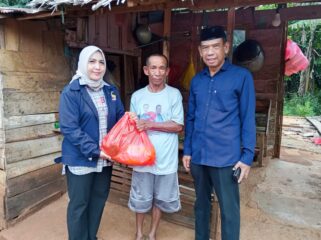 Ketua Partai Nasdem Kolaka, Hj. Sucianti Aras (kiri) bersama Sekretaris Nasdem Kolaka, Wardi (kanan) membagikan paket Ramadhan kepada selah seorang warga Pelambua, 