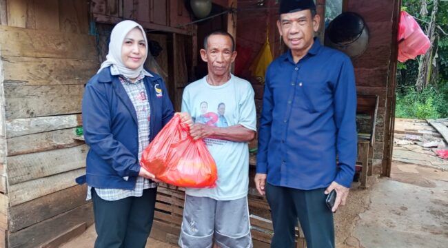 Ketua Partai Nasdem Kolaka, Hj. Sucianti Aras (kiri) bersama Sekretaris Nasdem Kolaka, Wardi (kanan) membagikan paket Ramadhan kepada selah seorang warga Pelambua, 