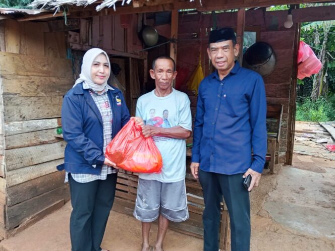 
 Ketua Partai Nasdem Kolaka, Hj. Sucianti Aras (kiri) bersama Sekretaris Nasdem Kolaka, Wardi (kanan) membagikan paket Ramadhan kepada selah seorang warga Pelambua, 